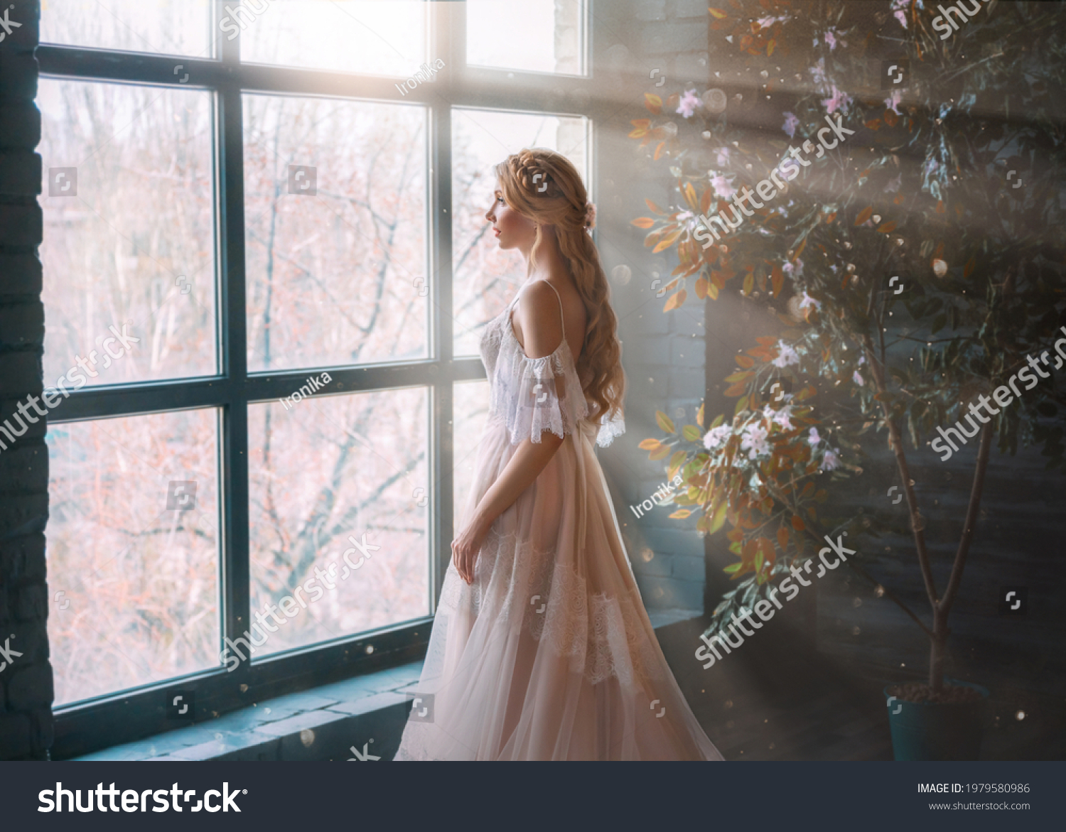 Romantic lady, blonde woman with long hair in white vintage dress stands in dark room, looks out window. Girl bride princess in wedding dress. Elegant hairstyle. Bright rays of sun concept of waiting. #1979580986