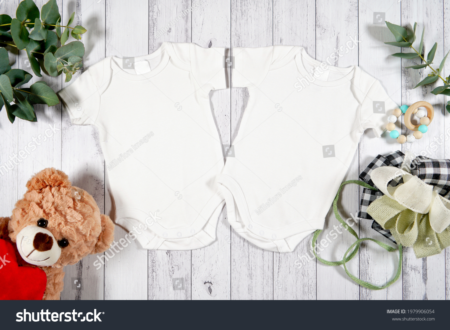Baby wear two twins rompers onesie flatlay. On-trend farmhouse theme craft product mockup with farmhouse style decor, on a white wood background. Negative copy space for your design here. #1979906054