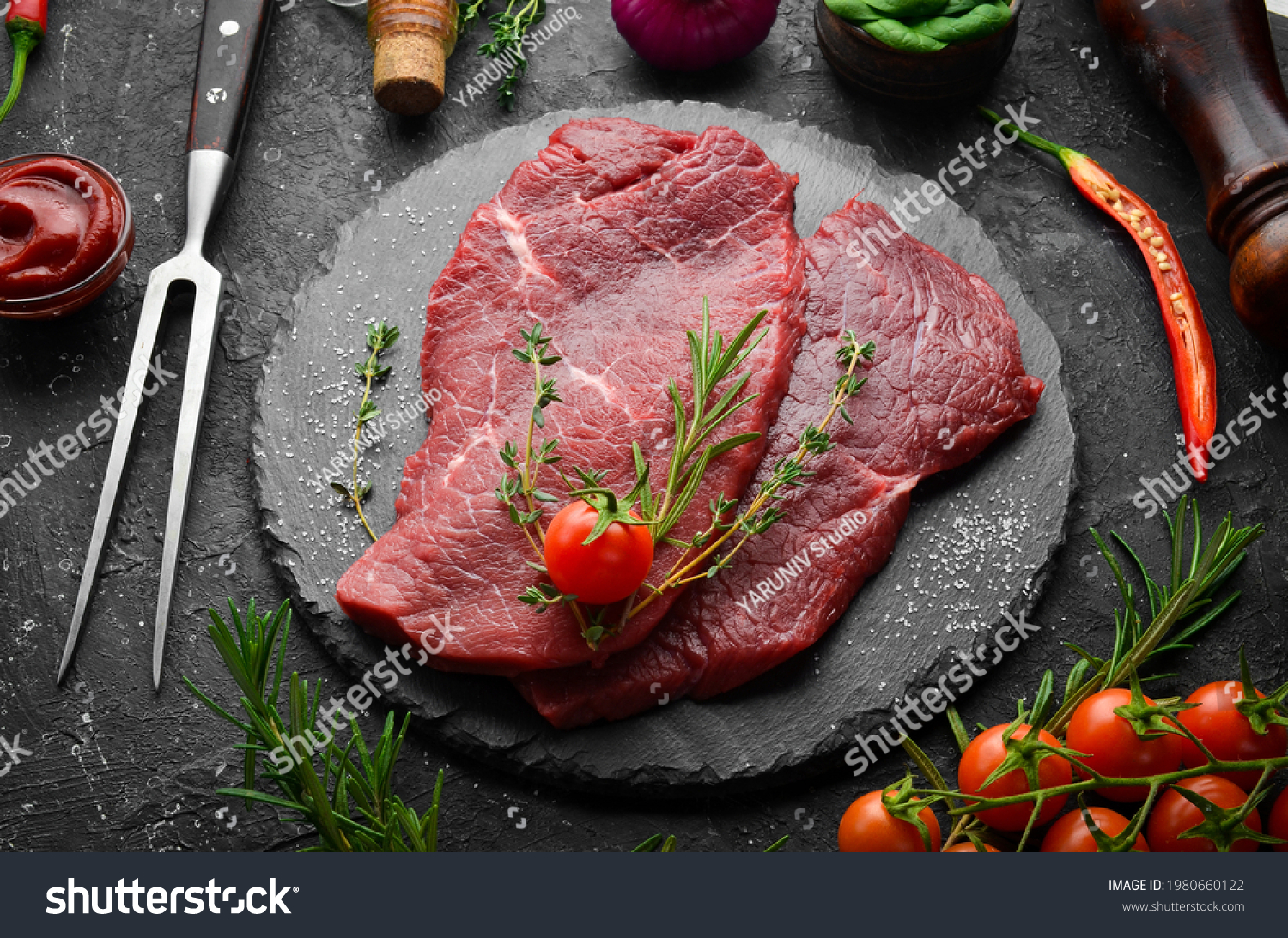 Meat. Raw veal steak with rosemary and spices. On a black stone background. Top view. #1980660122