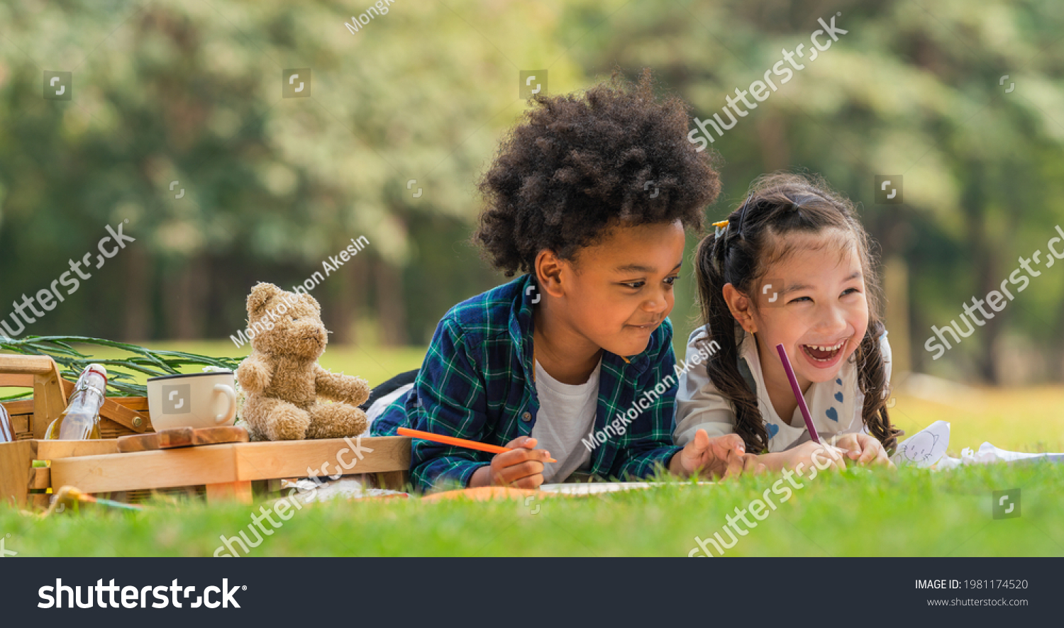 diverse mixed race kids boy and girl as friends having fun playing together during picnic in park in summer #1981174520