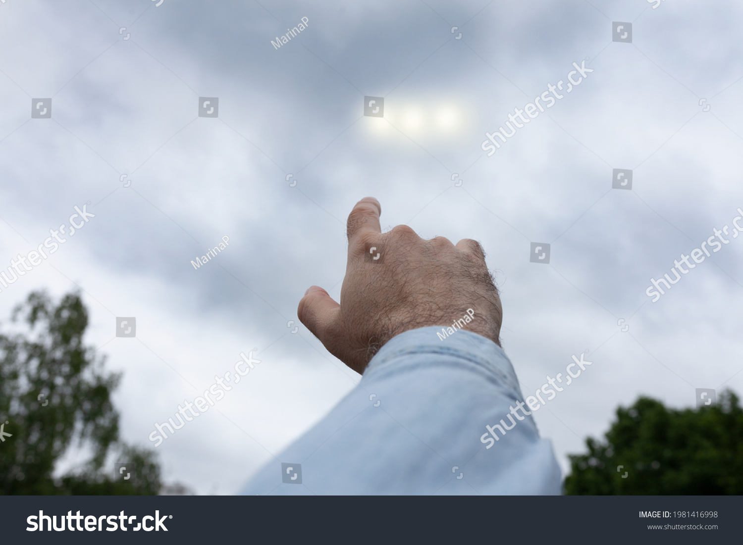 Man pointing finger at the strange lights in the sky, three light orbs among the clouds, UFO concept #1981416998