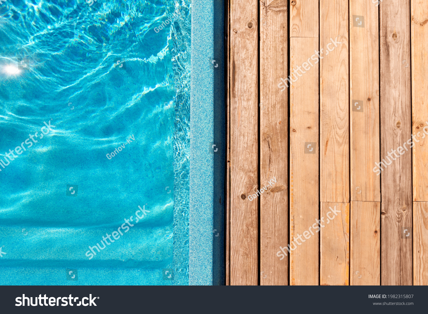 New modern fiberglass plastic swimming pool entrance step with clean fresh refreshing blue water on bright hot summer day at yard or resort hotel spa area. Wooden flooring deck of teak or larch board #1982315807