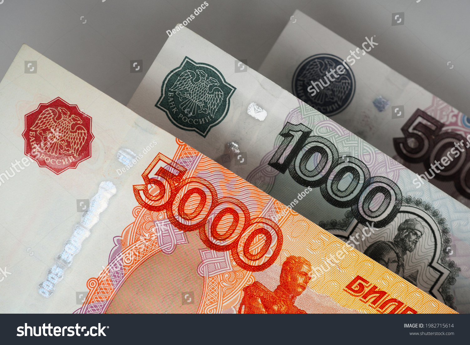 Russian banknotes 5000, 1000 and 500 rubles close up. Bright expressive illustration about economy and money of Russia. Nearest bill is highlighted in vivid color, other notes are pale. Macro #1982715614