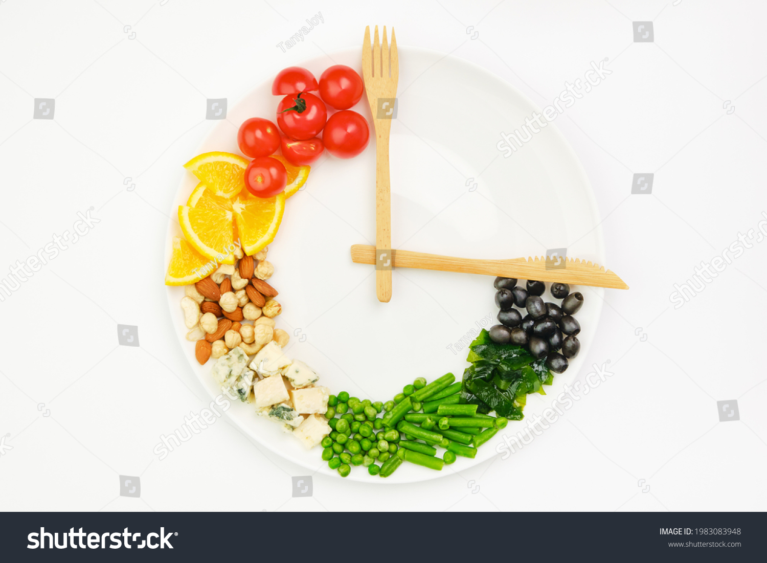 Colorful food and cutlery arranged in the form of a clock on a plate. Intermittent fasting, diet, weight loss, lunch time concept. #1983083948