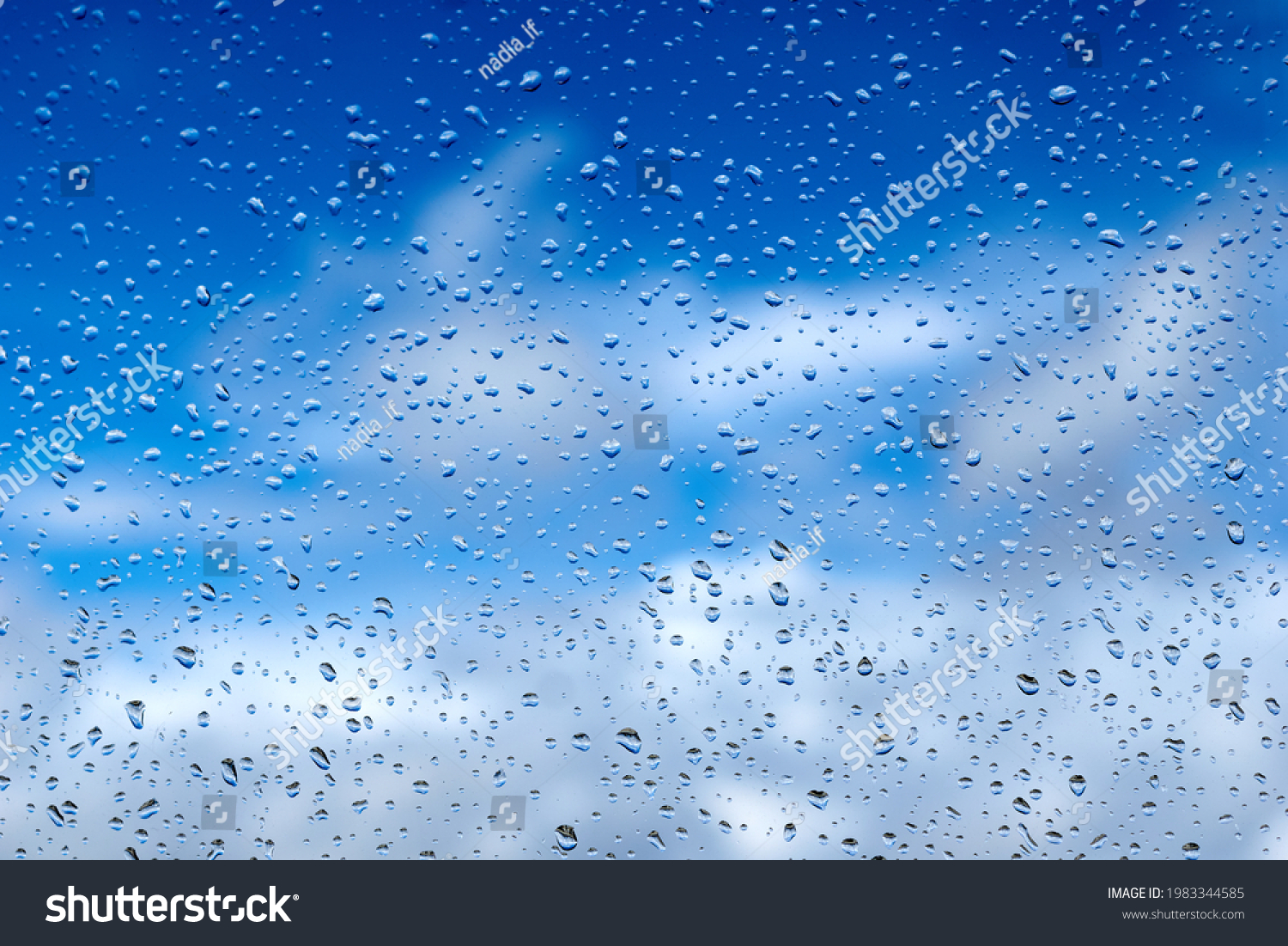 Rain drops on the glass. Beautiful blue and white sky. Sky background #1983344585