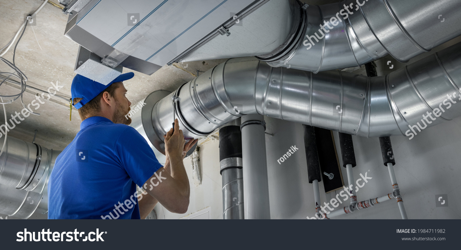hvac worker install ducted pipe system for ventilation and air conditioning. copy space #1984711982