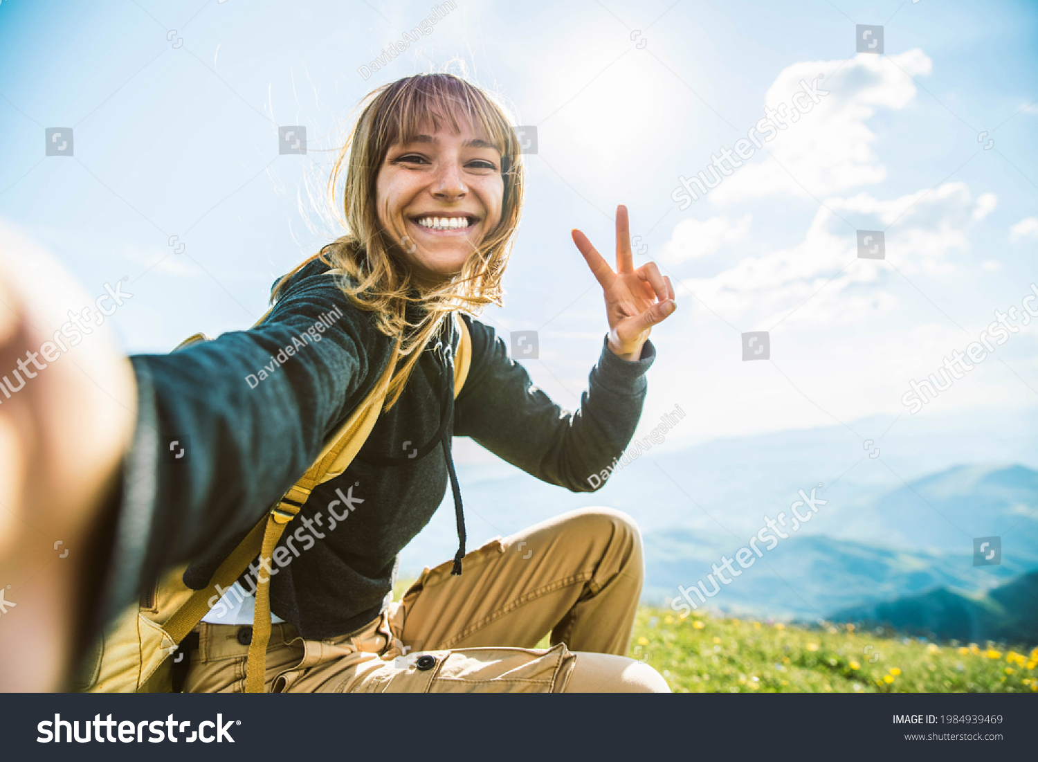 Young woman taking selfie portrait hiking mountains - Happy hiker on the top of the cliff smiling at camera - Travel and hobby concept #1984939469