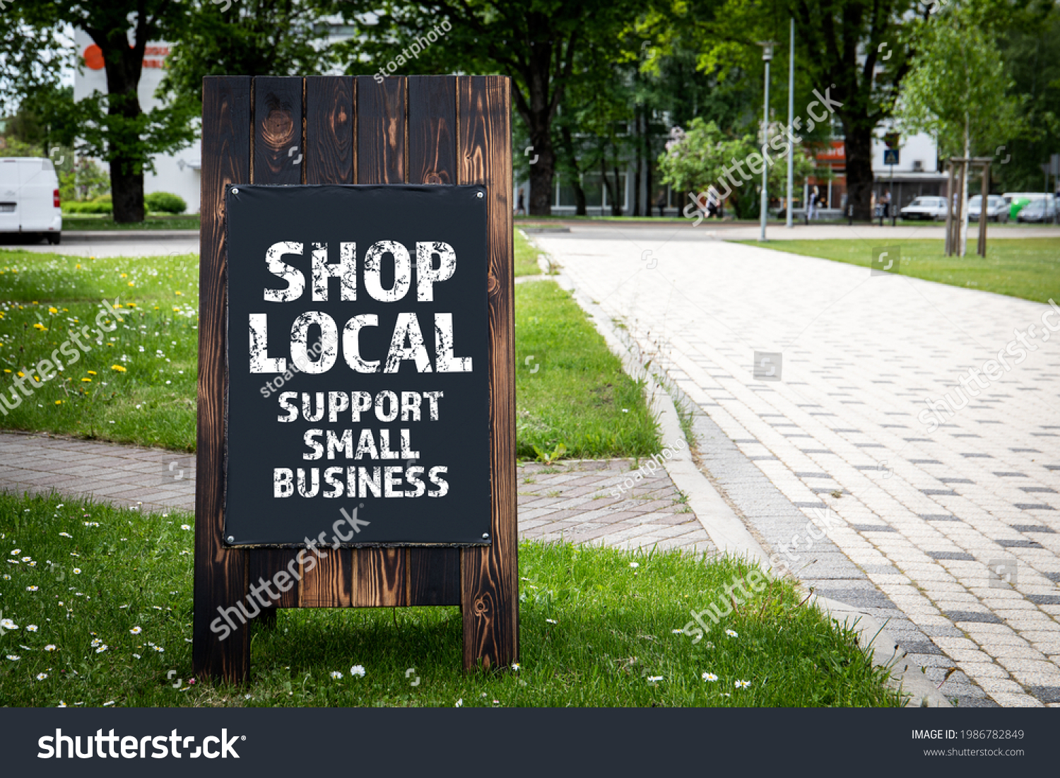 Shop Local. Support small business. Wooden billboard on the street, sunny day. #1986782849