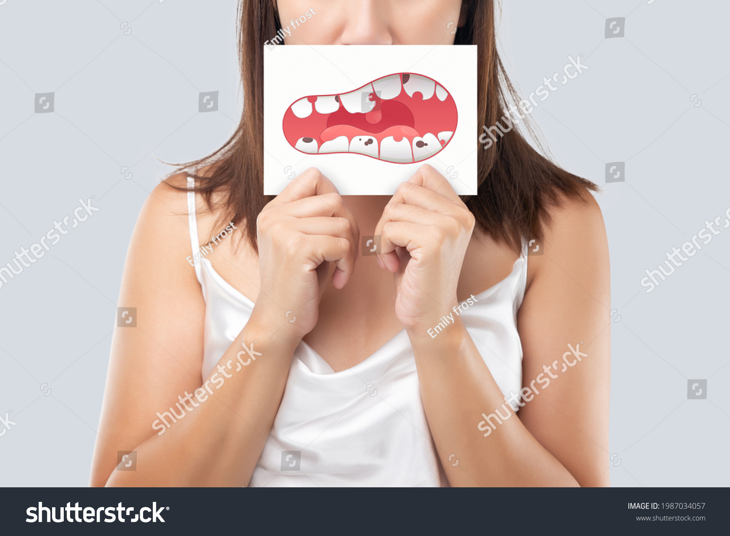 The woman show the picture of caries problems, Illustration health gums and teeth on a white paper. Decayed tooth. #1987034057