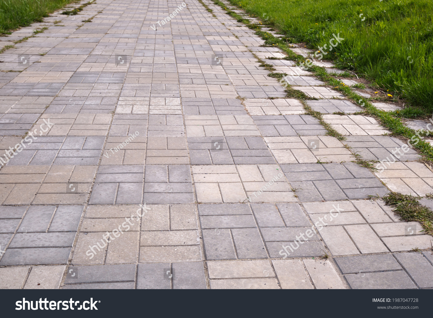 Concrete bricks footpath on the green grass in the park, abstract background of tiles, footpath, sidewalk,  #1987047728