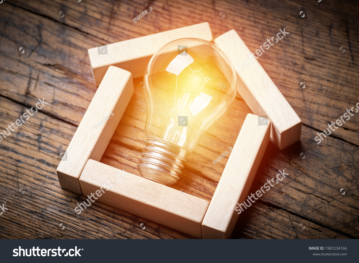 house shape made by wooden block with light bulb inside. energy saving concept. estate business conceptual. . #1987234166
