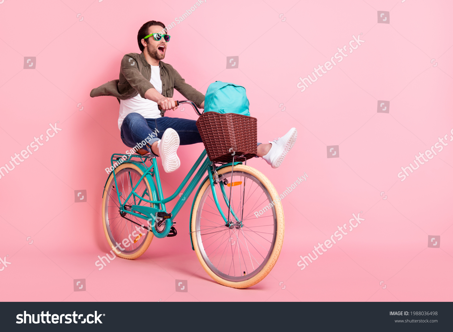 Photo of sweet cute guy dressed brown shirt dark eyeglasses riding bike backpack looking empty space isolated pink color background #1988036498
