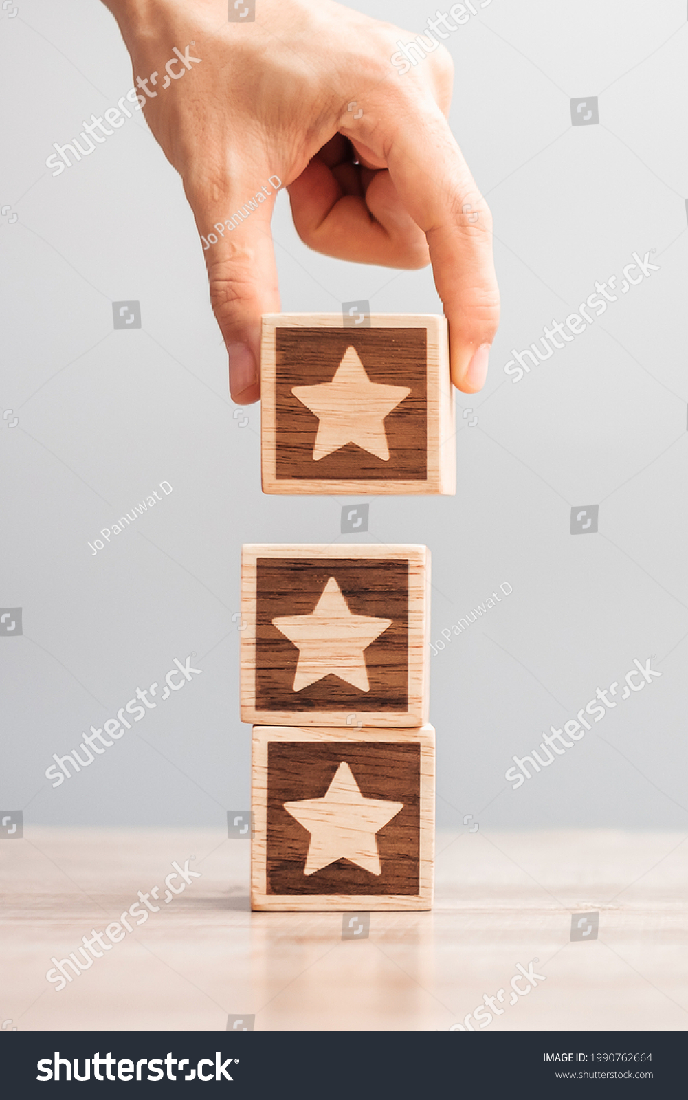 Man hand holding Star block. Customer choose rating for user reviews. Service rating, ranking, customer review, satisfaction, evaluation and feedback concept #1990762664