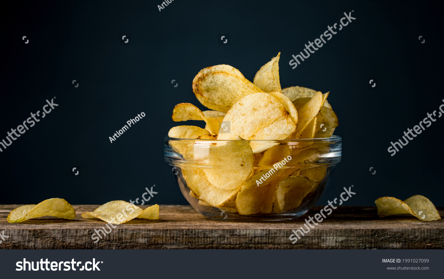 Potatoes Chips. Chips in glass bowl good for snack for beer or ale on natural wooden table. Good for beer festival, pub, restaurant advertising. Food and Drink photography. Macro high resolution Photo #1991027099