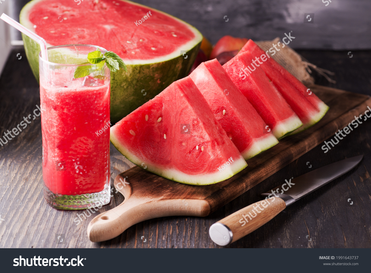 Fresh watermelon juice with ice in a glass. Slices of watermelon on the table.Fresh watermelon juice with ice in a glass. Slices of watermelon on the table. #1991643737