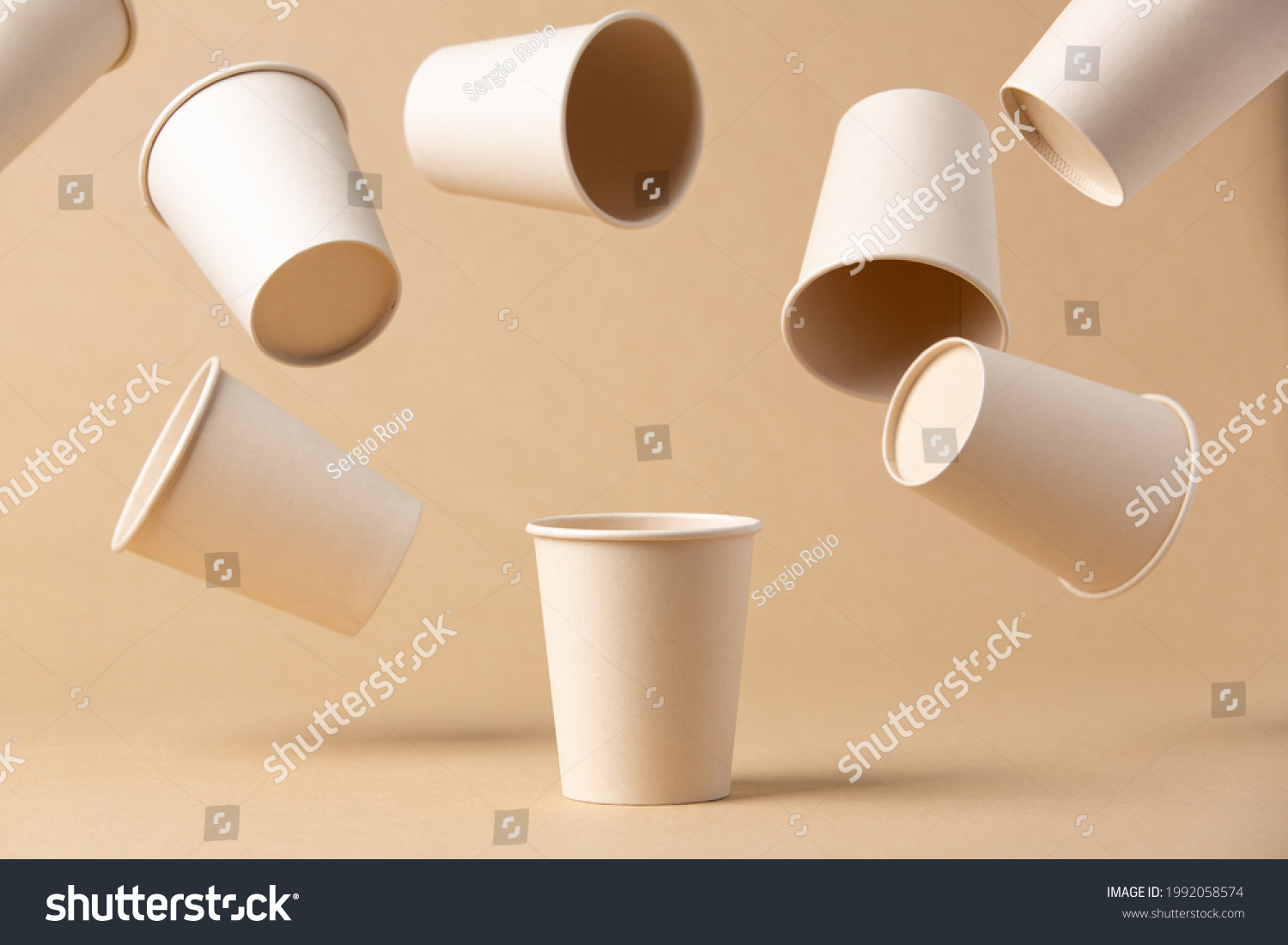 many recyclable cardboard cups floating on a kraft cardboard bottom #1992058574