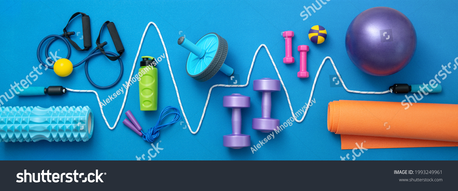 still life of group sports equipment for womens and cardiogram of jump rope, on blue background. Fitness and healthy living, wellness concept. #1993249961
