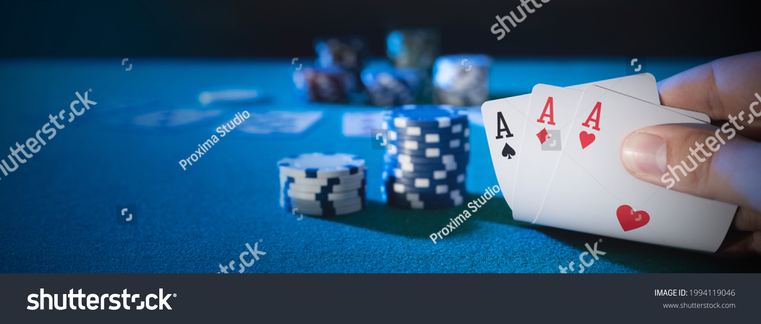 Hand picks up cards, three aces, plays casino poker. Background with copy space #1994119046