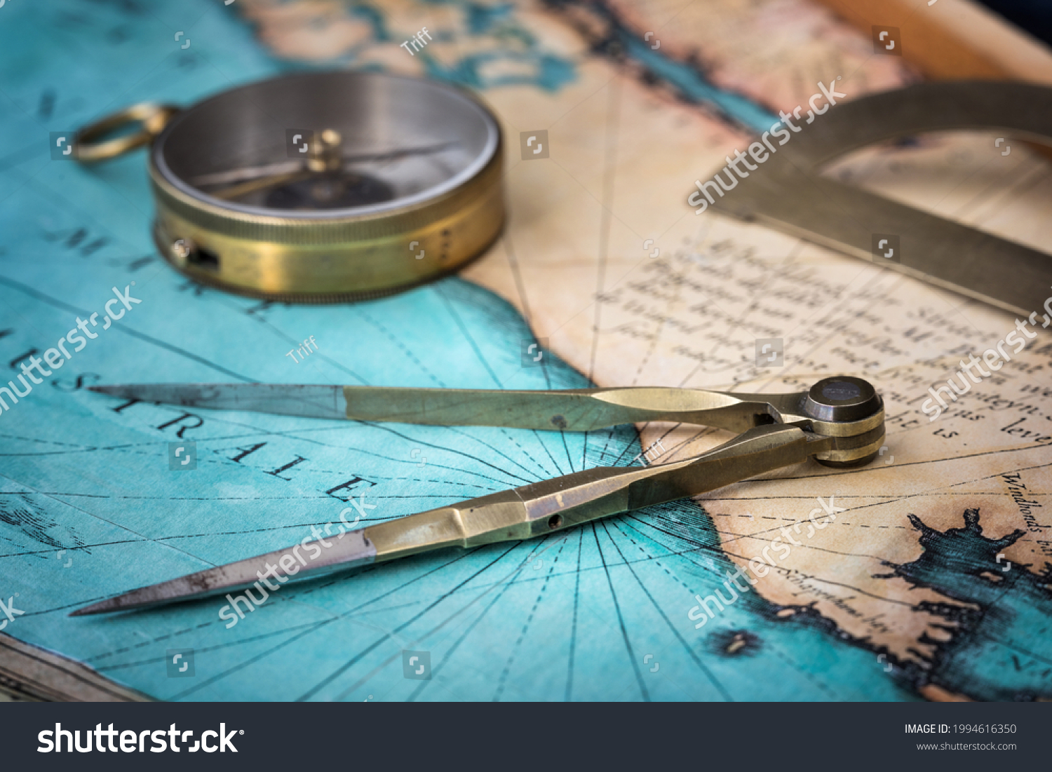 An old geographic map with navigational tools: compass, divider, protractor. View of the workplace of ship's captain. Travel, geography, navigation, tourism, history and exploration concept background #1994616350