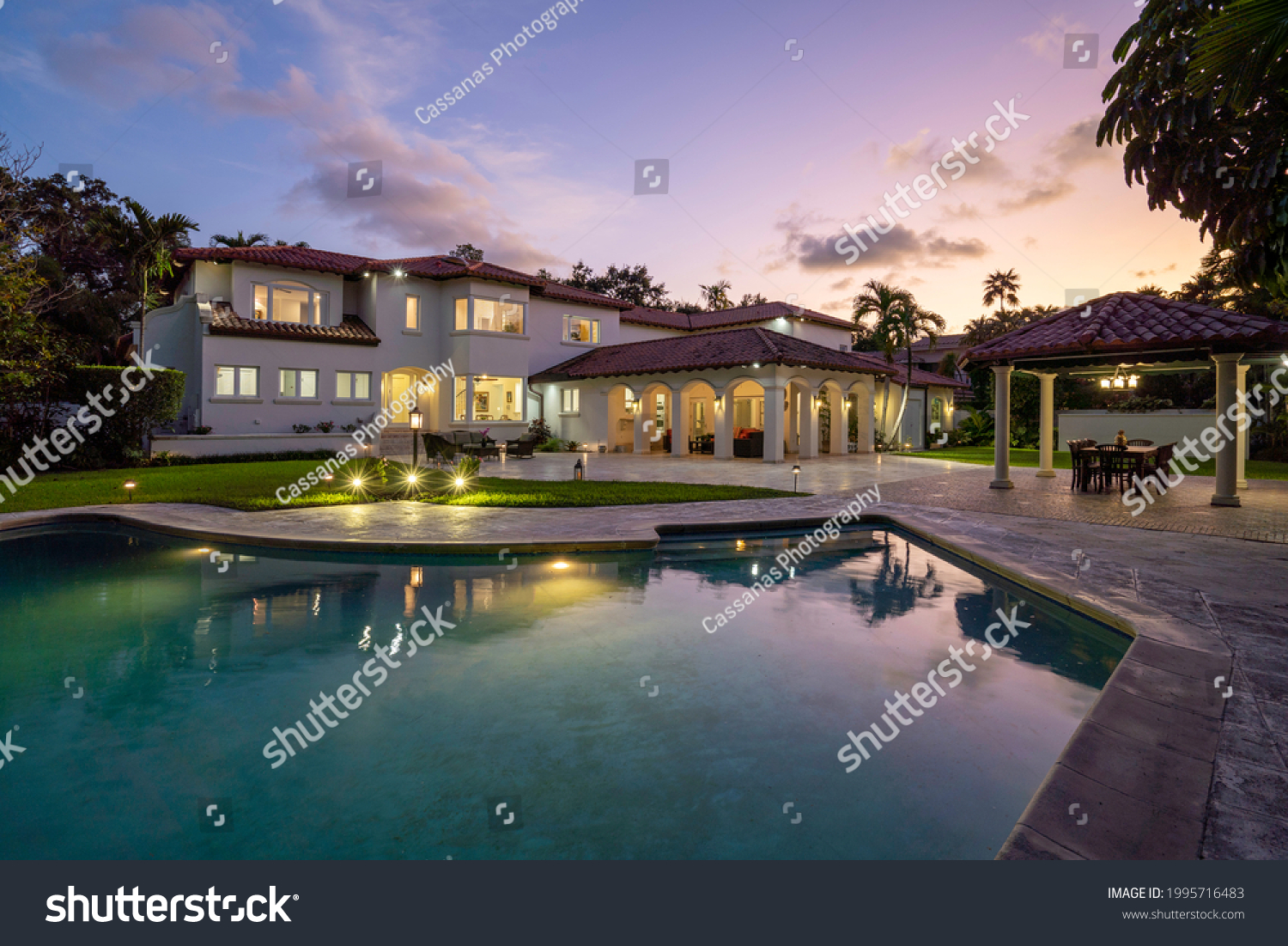 Spanish mansion, sky at dusk and a great pool for swimming. Miami, Florida. #1995716483