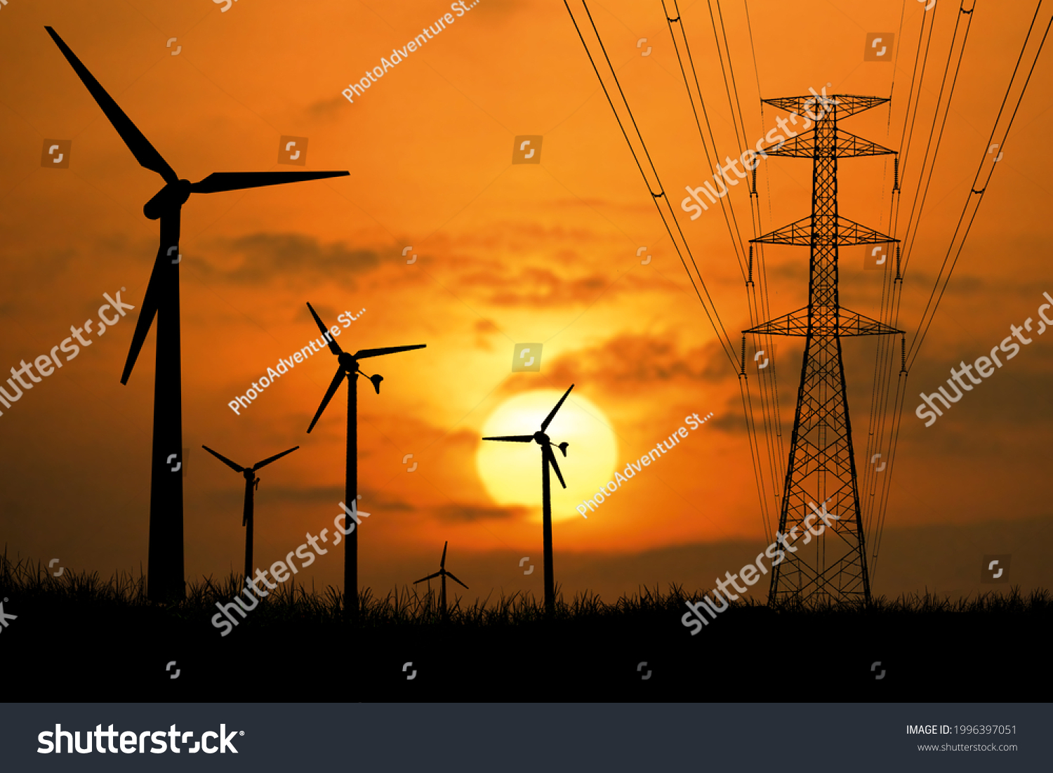 Silhouettes of wind turbines and high-voltage poles in a field at sunset. #1996397051