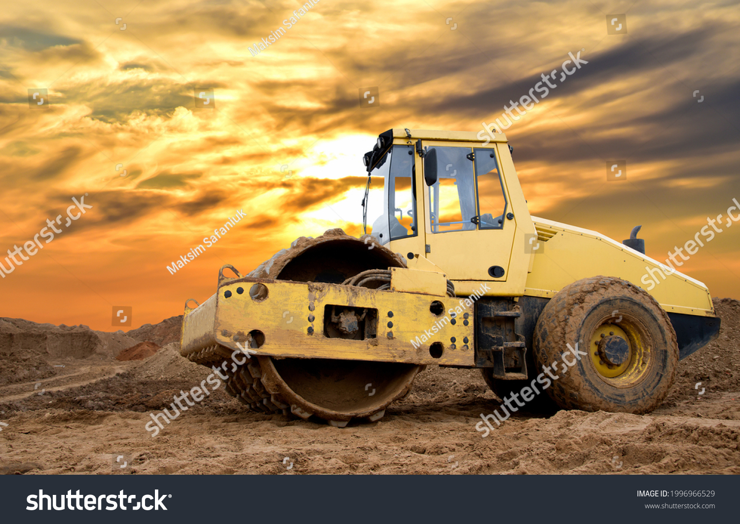 Soil Compactor for leveling ground for the foundation and on road construction. Road compaction equipment at construction site. Vibration single-cylinder road roller on amazing sunset background. #1996966529
