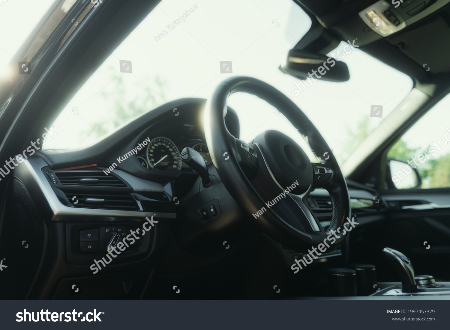 Black premium car interior. Dashboard, steering wheel, speedometer at sunny day #1997457329