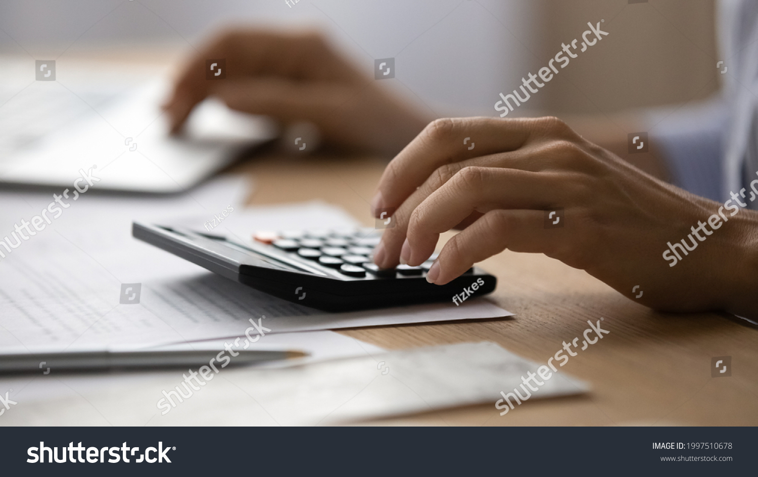 Close up young woman using calculator, managing household monthly budget, summarizing taxes or bills, planning future investments, doing financial affairs at home, accounting bookkeeping concept. #1997510678