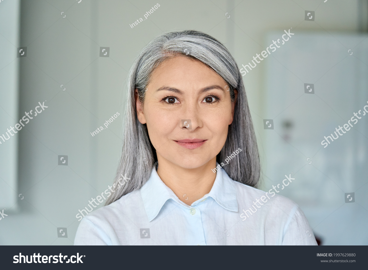 Happy confident middle aged Asian older senior female lawyer businesswoman corporation ceo in modern office looking at camera. Business woman executive concept. Closeup portrait headshot. #1997629880