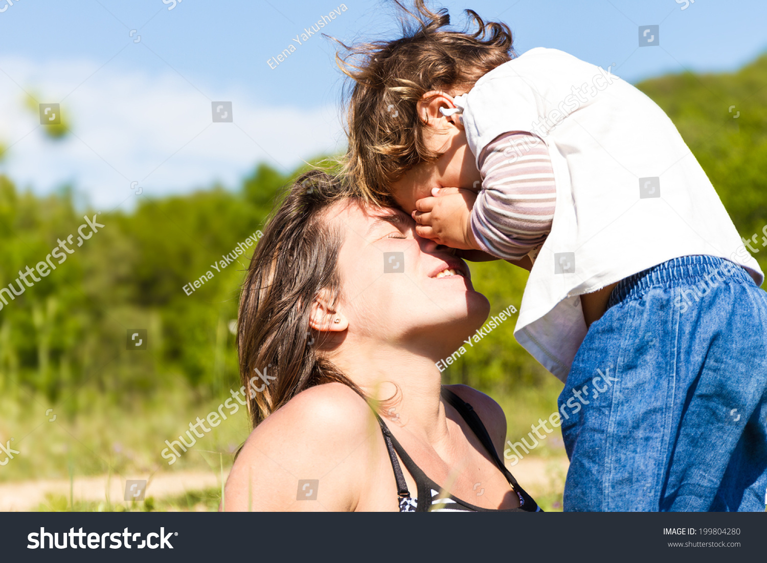 young happy mother playing with her child girl outdoors #199804280