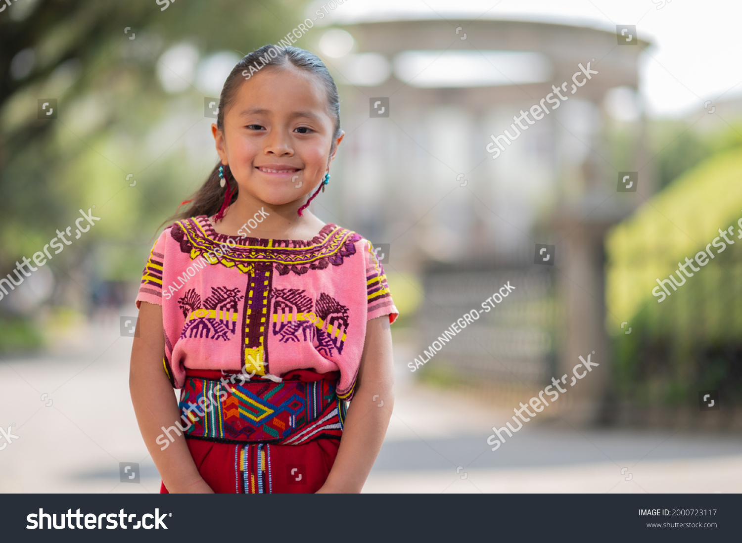 Portrait of a beautiful indigenous girl with a colorful dress from Quiche. #2000723117