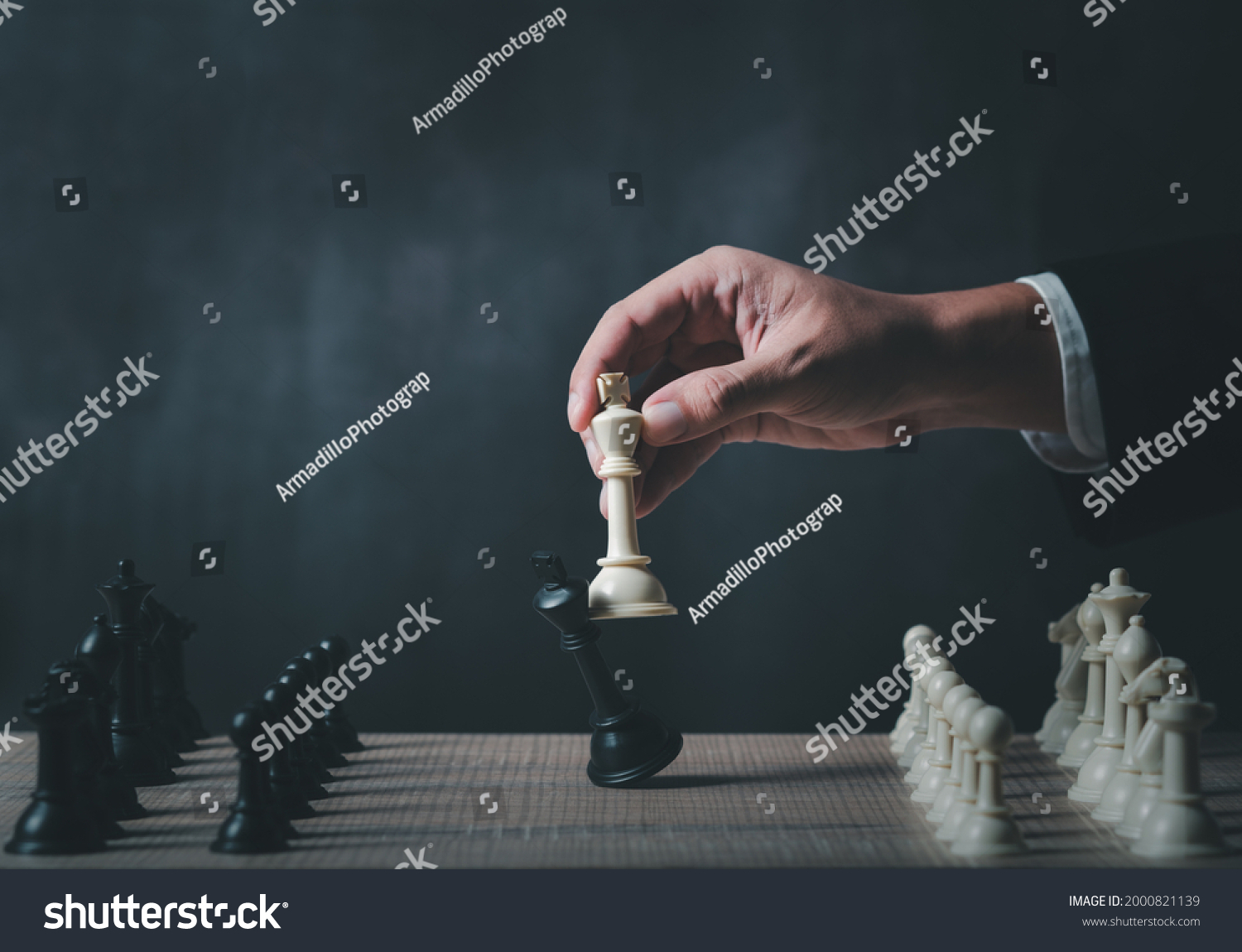 hand of businessman wearing suit moving chess figure in competition success play. strategy,teamwork, management or leadership concept. #2000821139