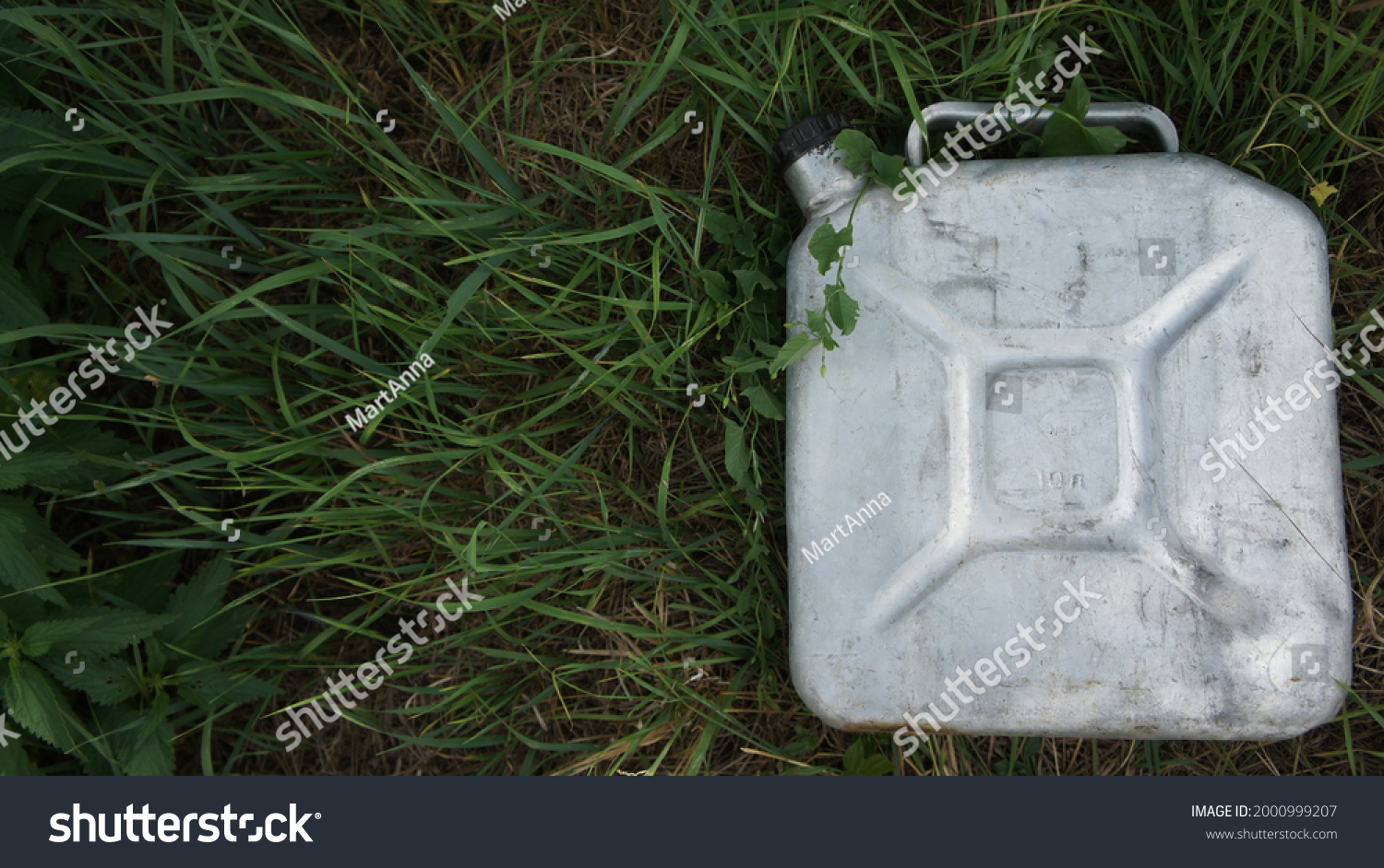 Aluminum can with gasoline in the grass. Biodiesel. Environmental protection. Ecology  #2000999207