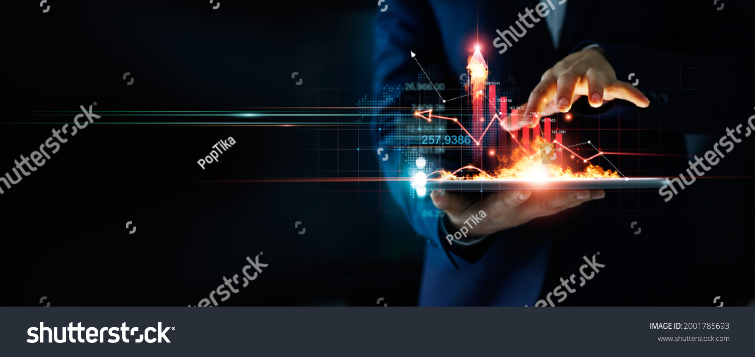 Business growth. Businessman holding tablet and a hot of fire glowing upright arrow with analyzing data and economic growth graph. Strategy. Stock market. Financial and banking. Digital marketing.  #2001785693