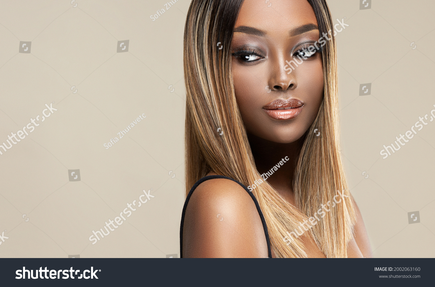 Beautiful African American woman with dyed and straight hair. The beauty of an afro black girl with a bob smooth hairstyle and toning. Keratin straightening. Treatment, care and spa procedures. #2002063160