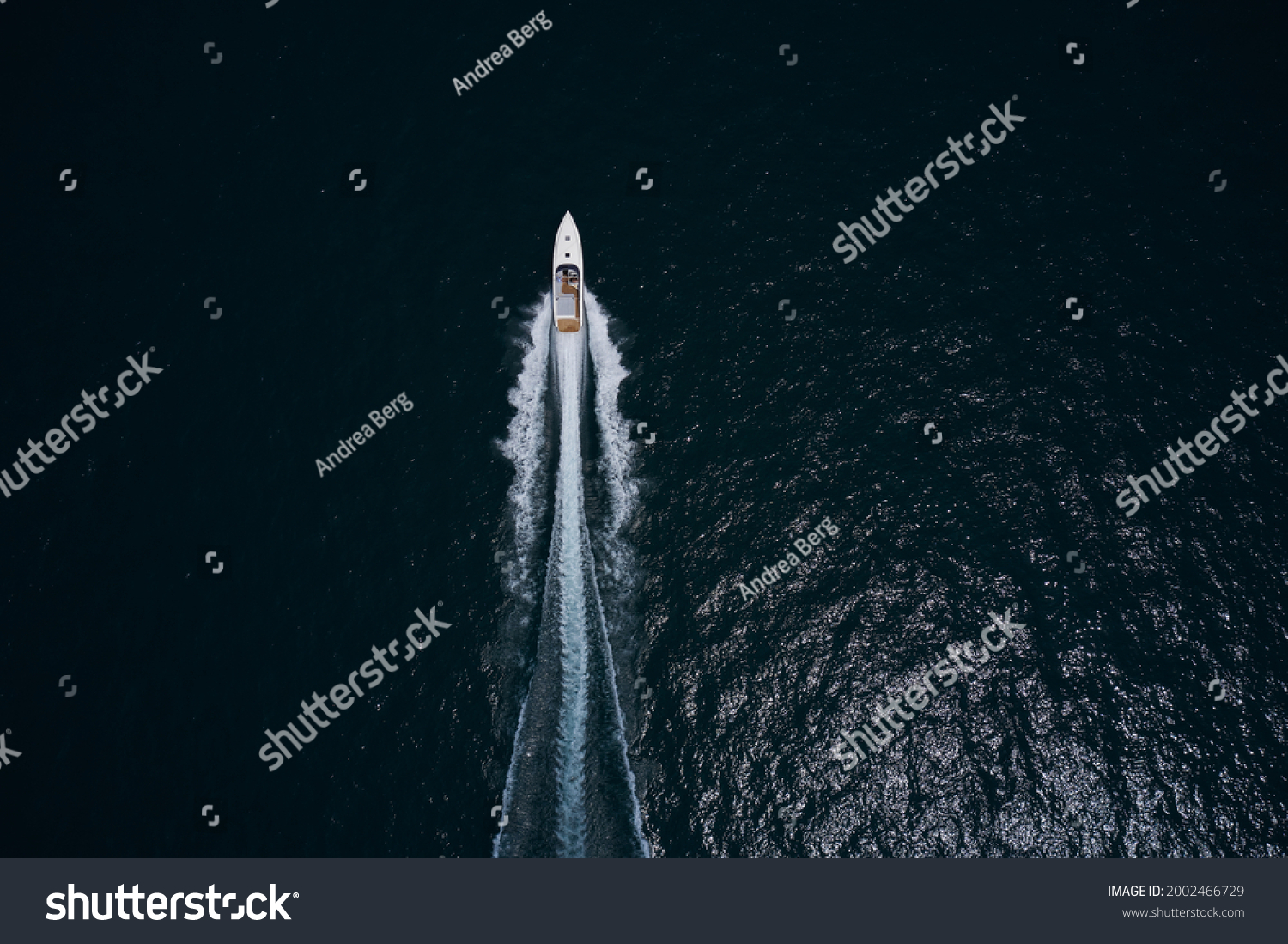 Speedboat movement on the water.Speedboat wave speed water. Large white boat driving on dark water. Speedboat on dark blue water aerial view. Speed boat faster movement top view. #2002466729