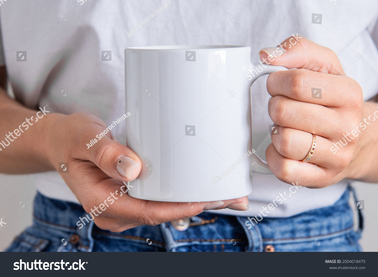 White coffee mug in the hands of the girl for presentation custom sublimation print. Blank mug photo mockup template #2004018479