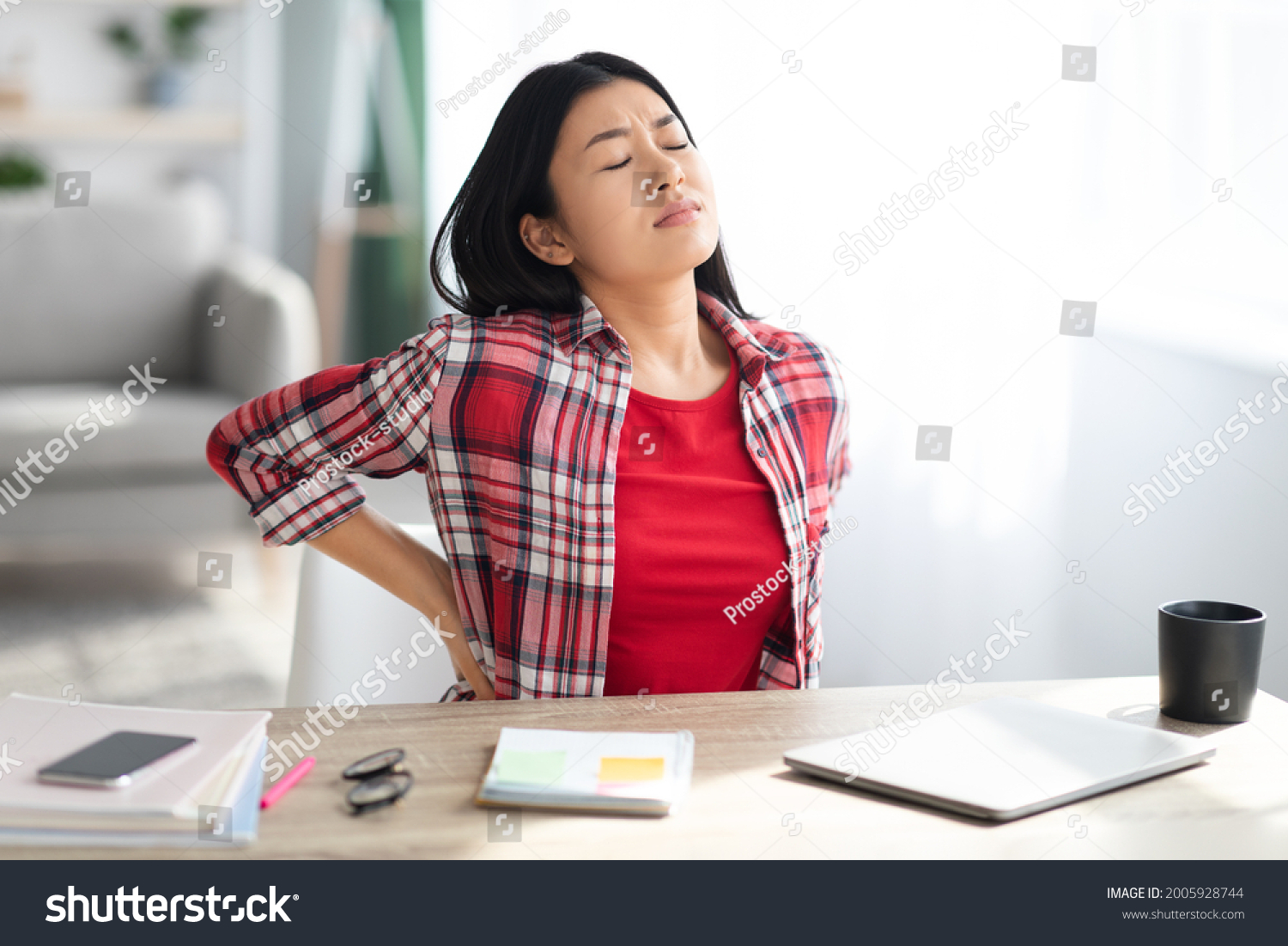 Beautiful Young Asian Woman Suffering From Backache While Sitting At Desk In Home Office, Tired Korean Freelancer Lady Having Acute Lower Back Pain After Long Time Working With Laptop Computer #2005928744