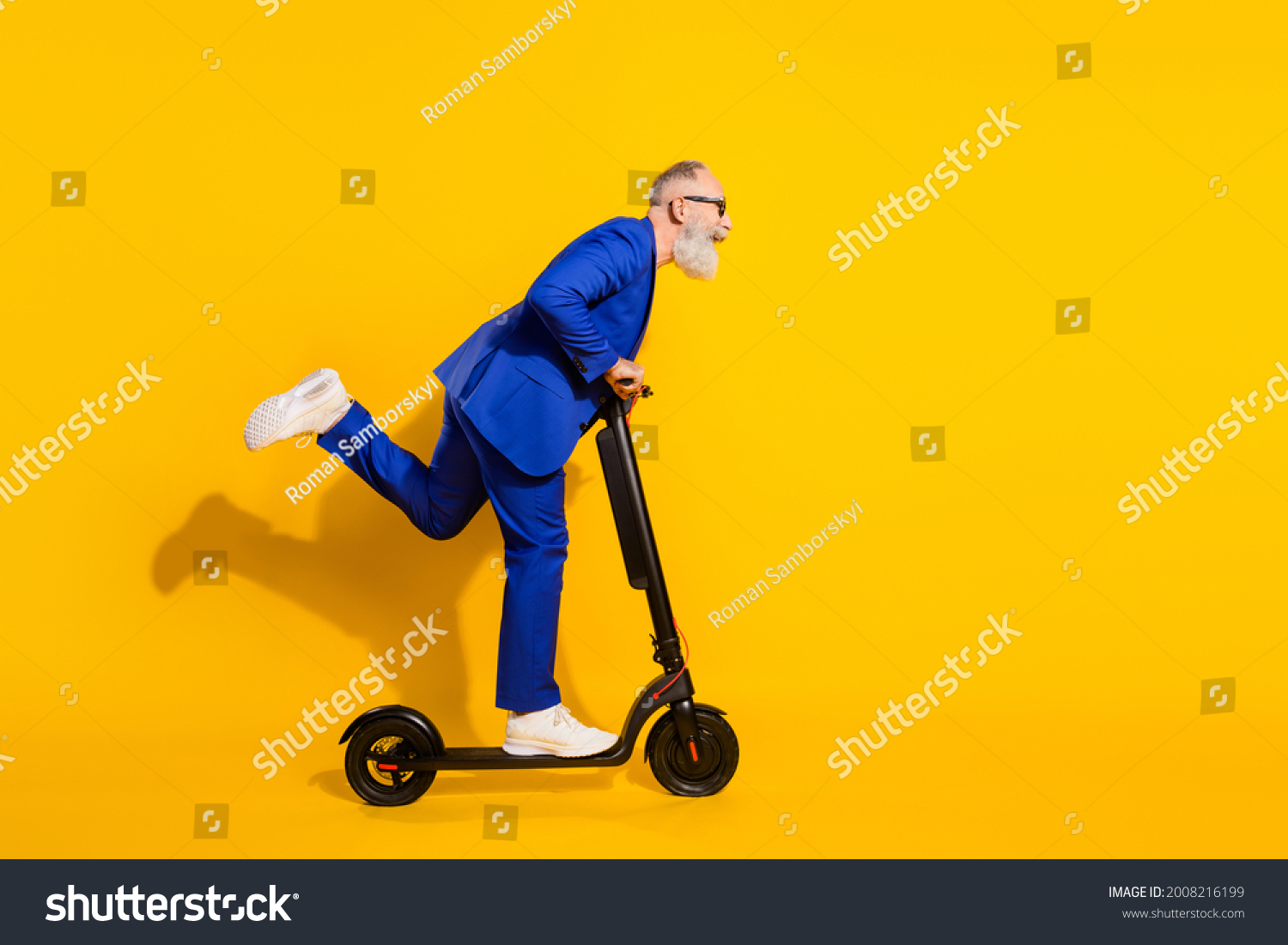 Full size profile side photo of happy excited crazy mature man look copyspace riding scooter isolated on yellow color background #2008216199