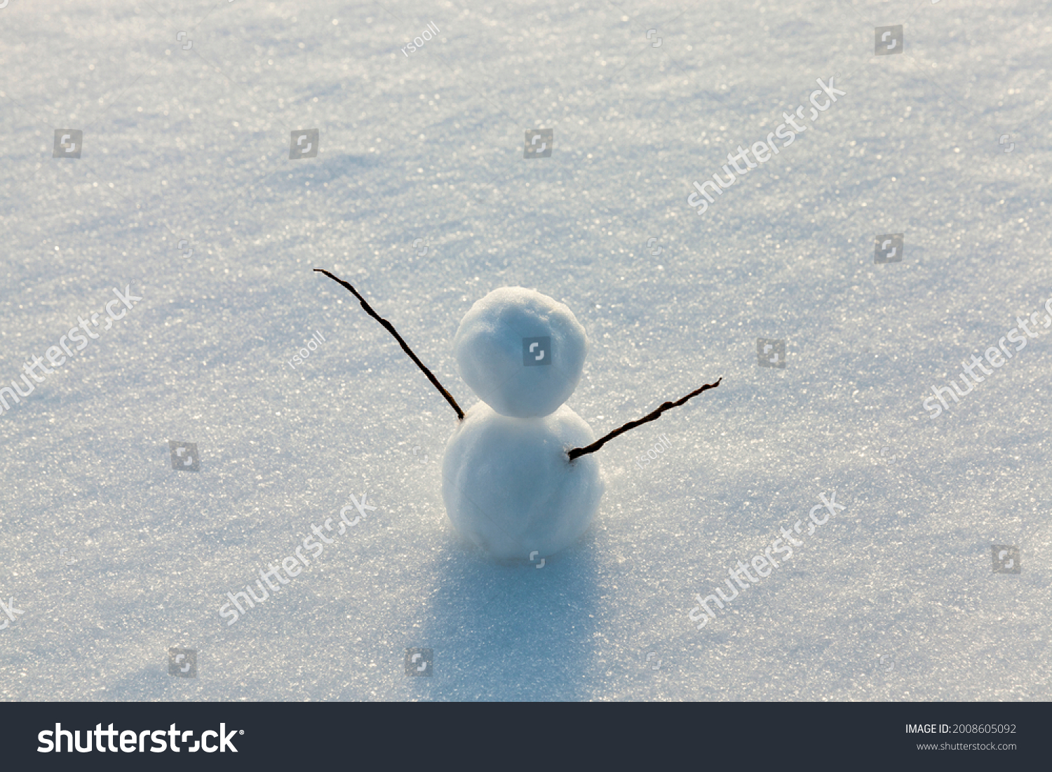 the snowman is made of several parts and stands in the snow in cold weather, one small snowman in the winter season, snow games with the creation of one snowman figure #2008605092