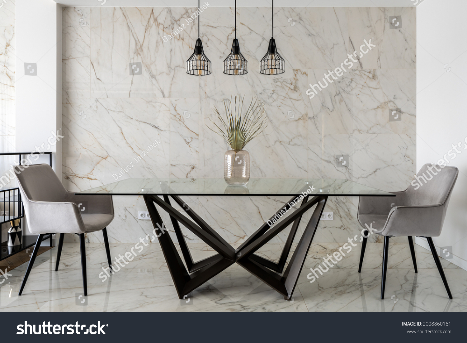 Stylish dining room with marble tiles on wall and floor and big, modern glass table with two chairs #2008860161