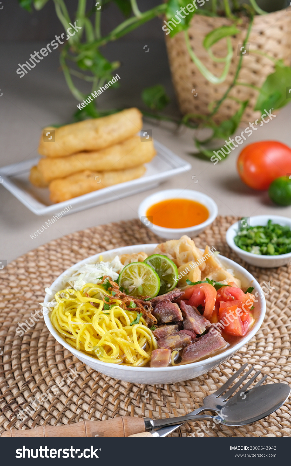 Soto Mie Bogor, Indonesian traditional beef noodle soup from West Java with noodles, beef, spring roll, cabbage, and tomato. Served with chili sauce and lime. #2009543942