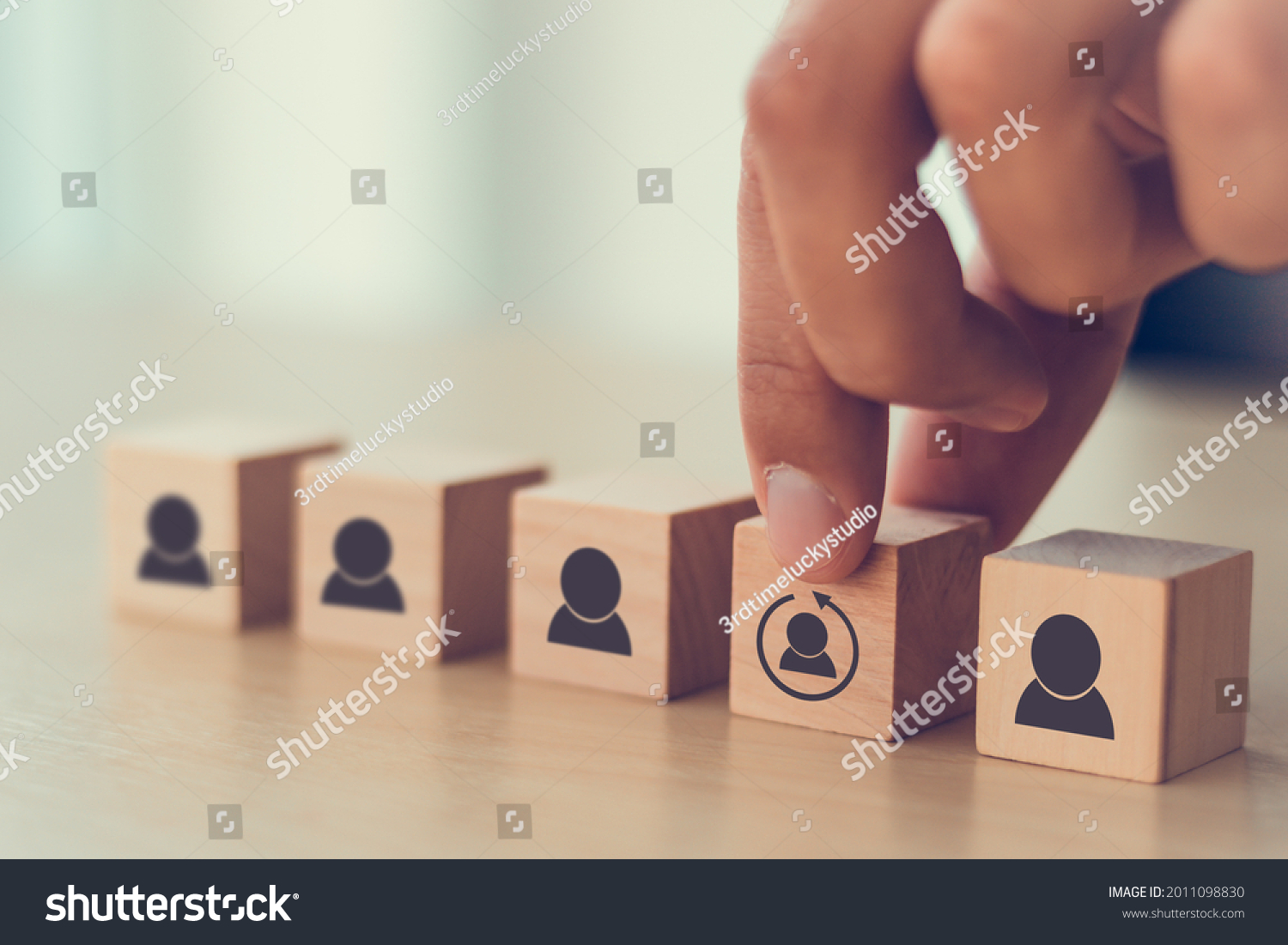Re-skill concept to training employees on an entirely new set of skills for business growth and digital transformation. Man holds wood cube with re-skill icon on many staff icon symbol;  Copy space.  #2011098830