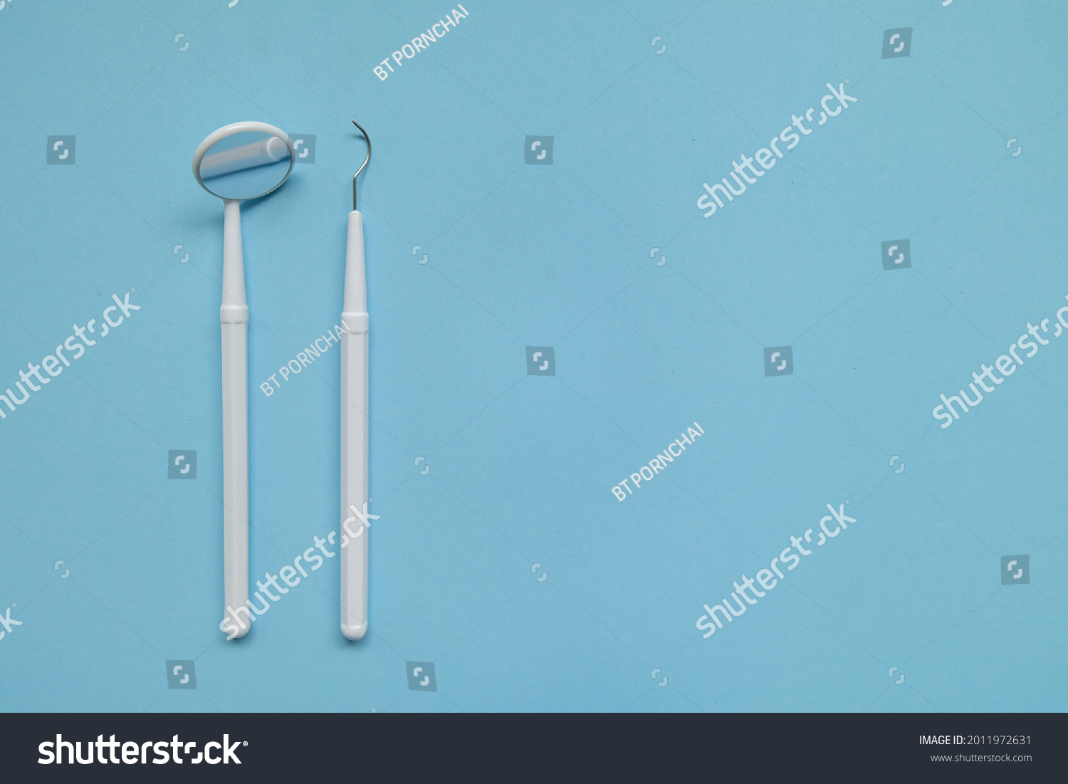 Dentist tools, Dental Mirror, Dental Scaler. Dentist equipment on blue background #2011972631