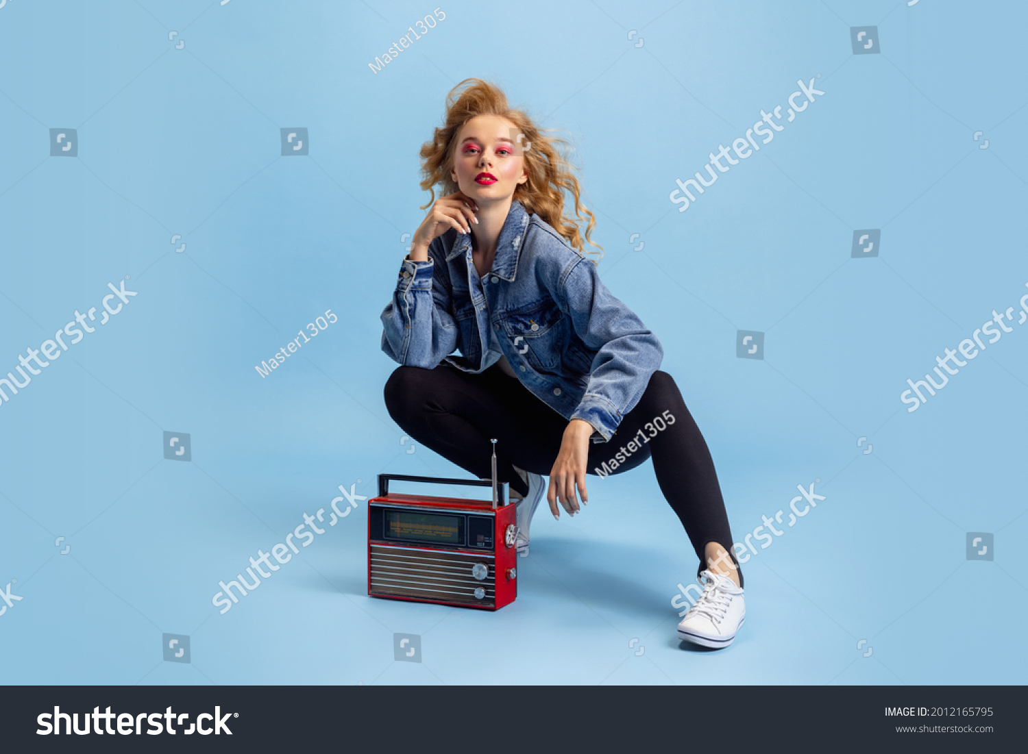 Disco, party time. Portrait of attractive woman in retro 90s fashion style, outfit isolated over blue studio background. Concept of eras comparison, beauty, fashion and youth. #2012165795