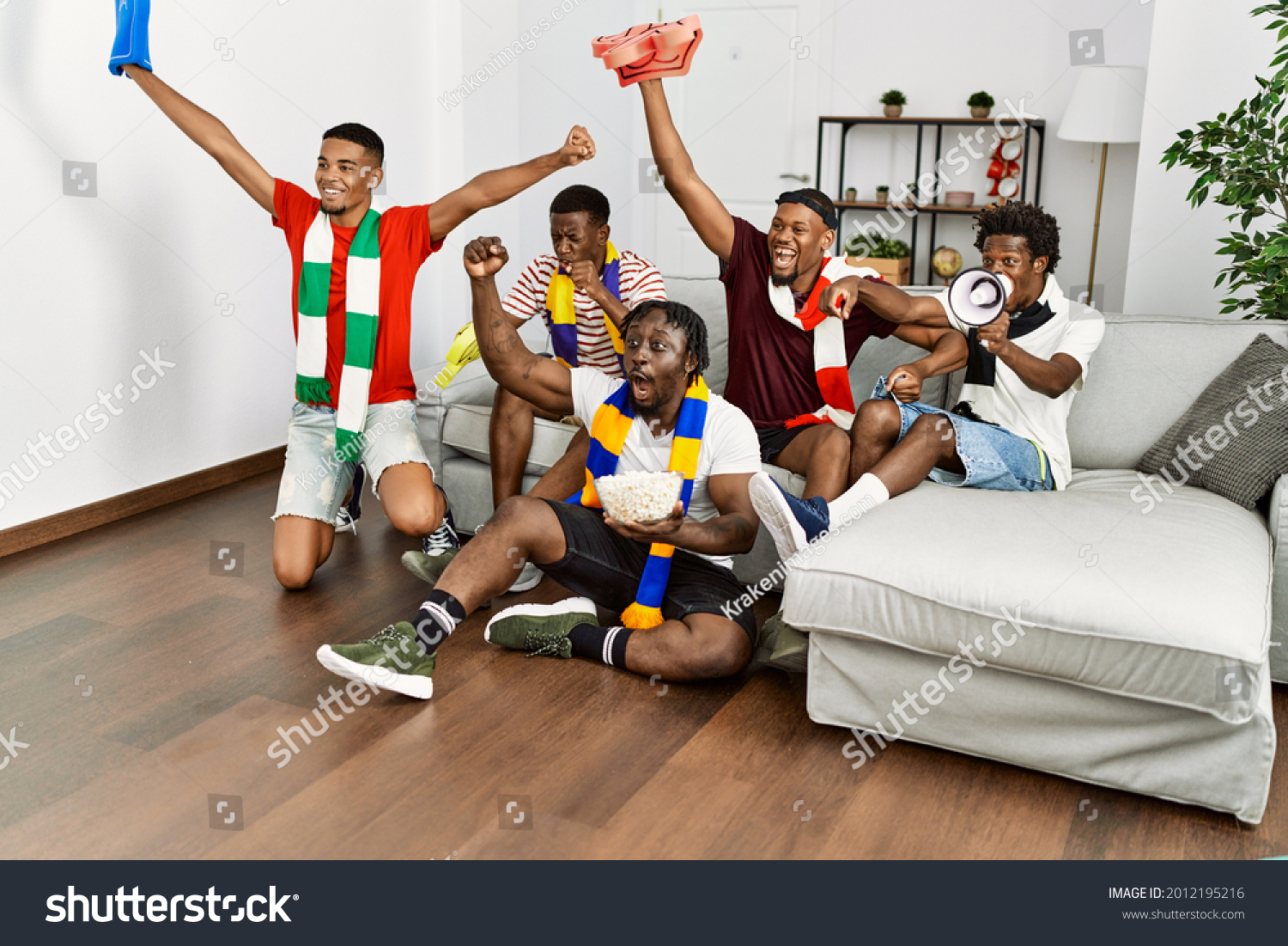 Group of young african american friends watching and supporting soccer match at home. #2012195216