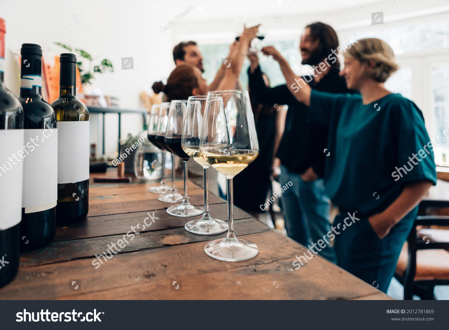 people inside a bar chilling out with a drink - friends talking and drinking in a winery - Millennials toasting at a wine tasting #2012781869