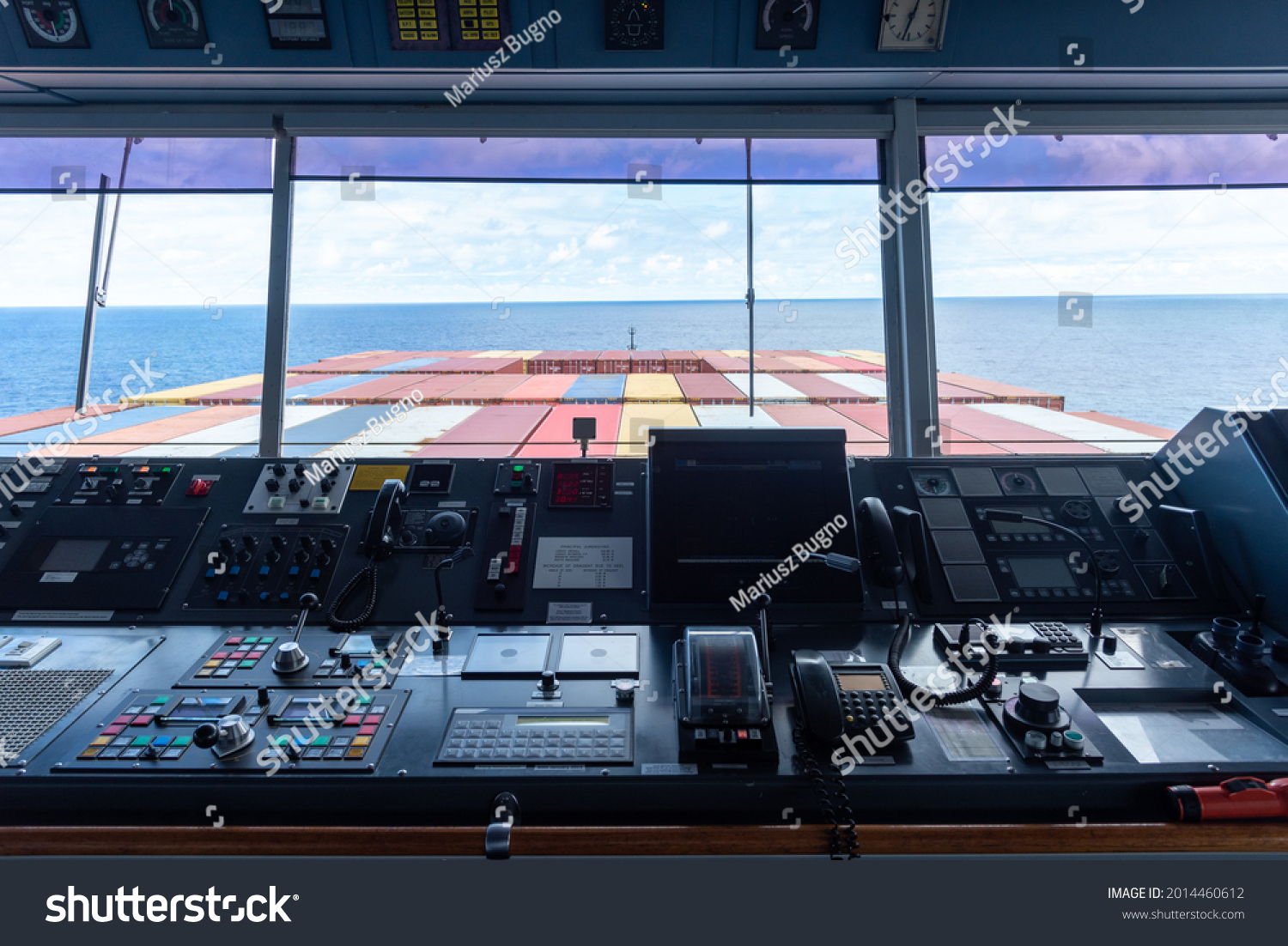 View of the control console on the navigational bridge of the cargo container ship.  #2014460612