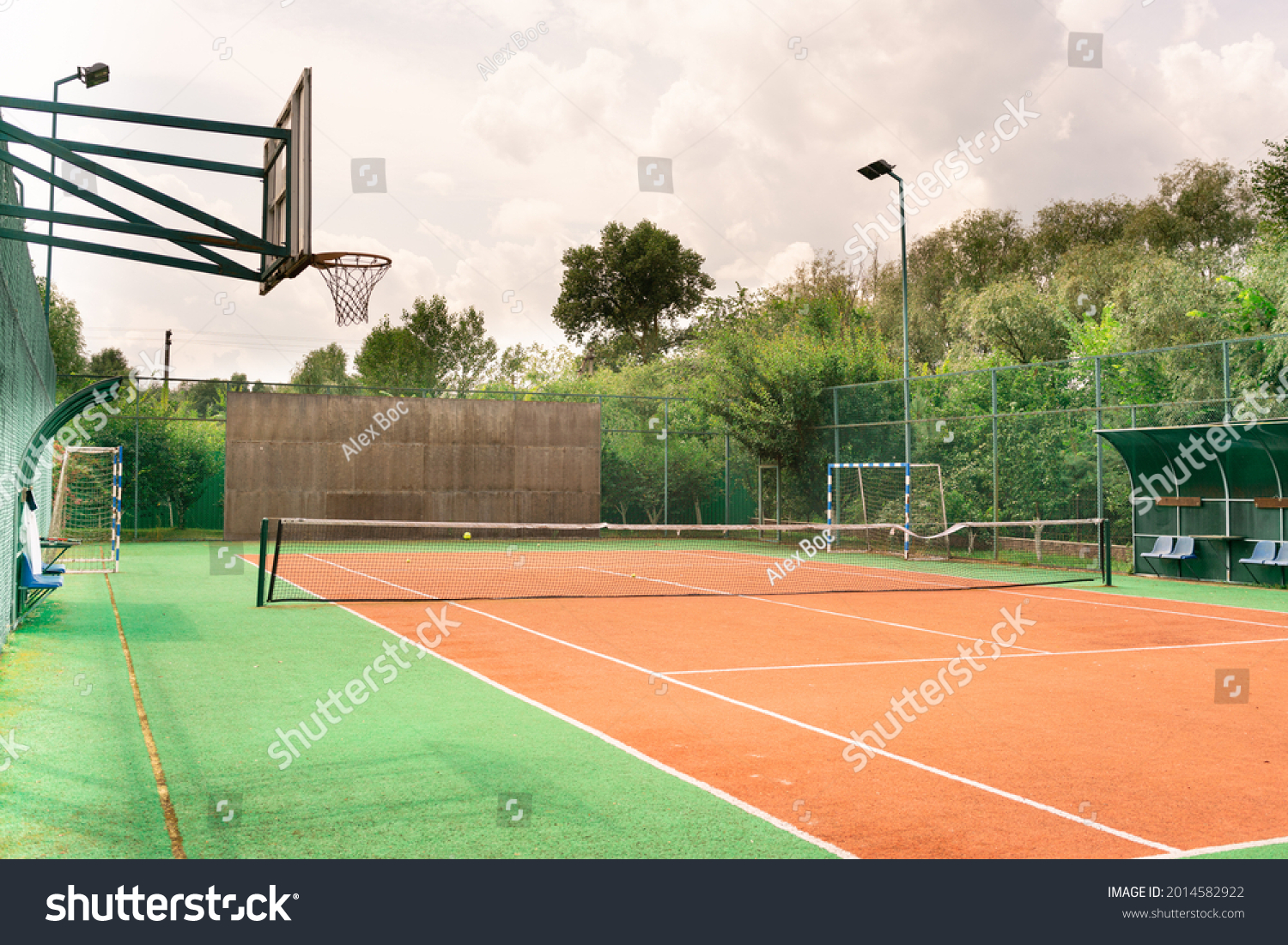 Mini outdoor sports ground, facilities for training and playing football, basketball, volleyball and tennis court. Active recreation in the park on a summer day surrounded by trees #2014582922