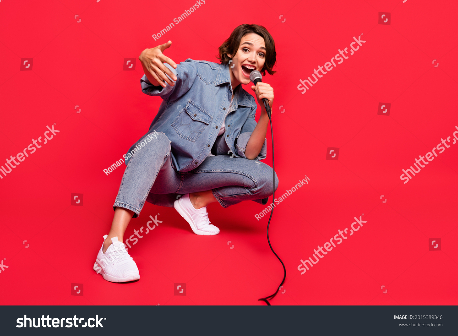 Full size photo of young woman happy positive smile singer rapper celebrity isolated over red color background #2015389346